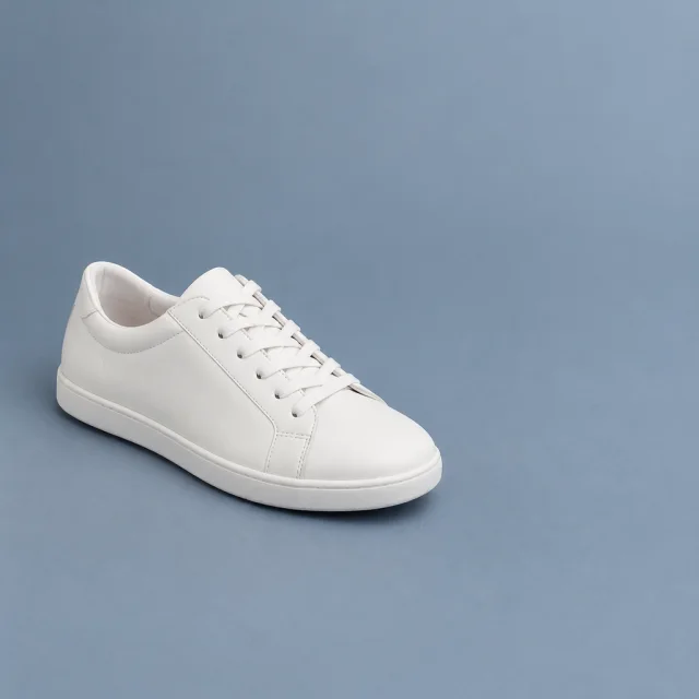 Plain white low shoe on a blue-gray background, with empty space beside it.