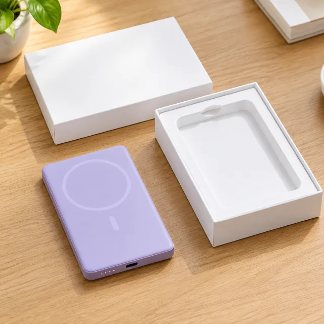 A second desk unboxing for the slim lavender magnetic power bank, with a tighter shot of it snapping onto the back of the phone.