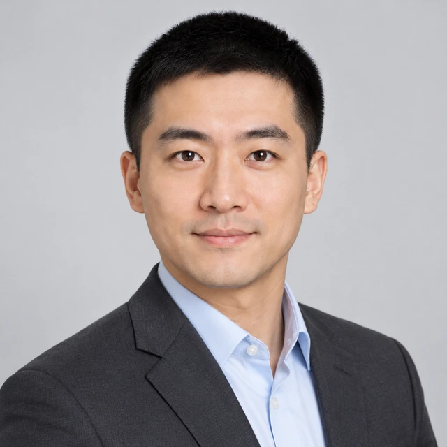 Matching team headshot of the same adult East Asian man in a charcoal blazer against a pale gray studio background.