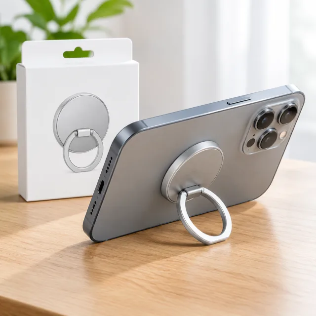 At his desk, a creator snaps a silver magnetic ring grip onto his phone and shows the hold, the stand angle and one-handed use.