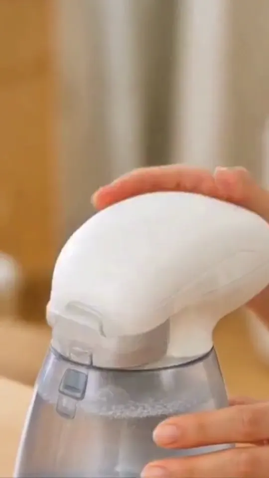 Hands fill a portable steam iron, switch it on, and press a blue shirt.