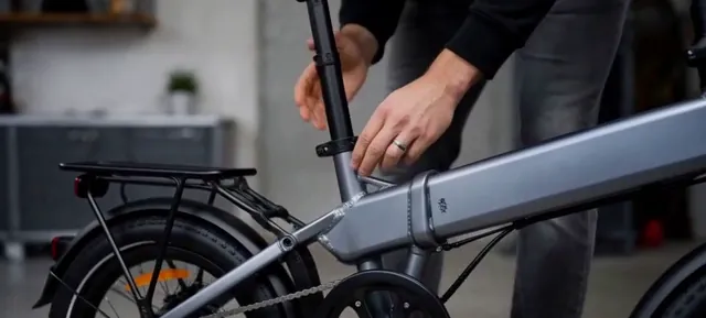 Close view of a hand on the frame of a folding electric bike