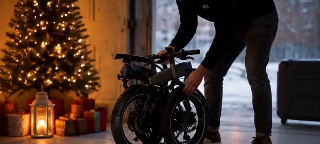 Folded electric bike beside a decorated Christmas tree with warm lights