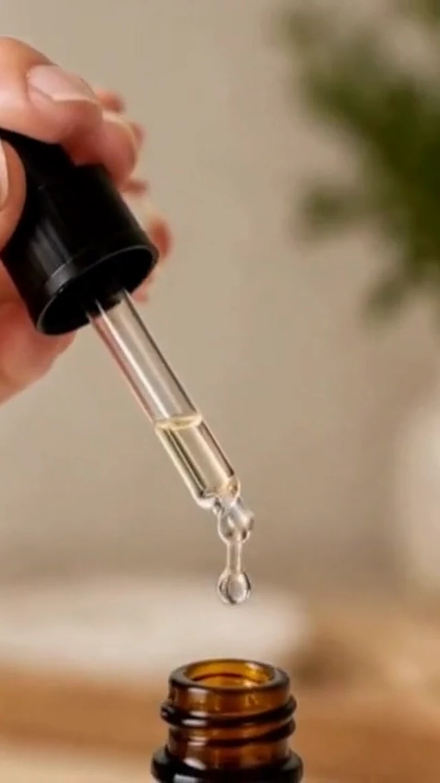 A real vertical frame from the local beauty routine clip showing a serum dropper over its bottle.