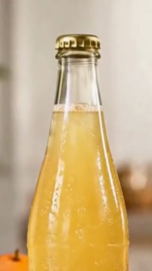 Clear citrus drink bottle on a bright counter in a vertical video frame.
