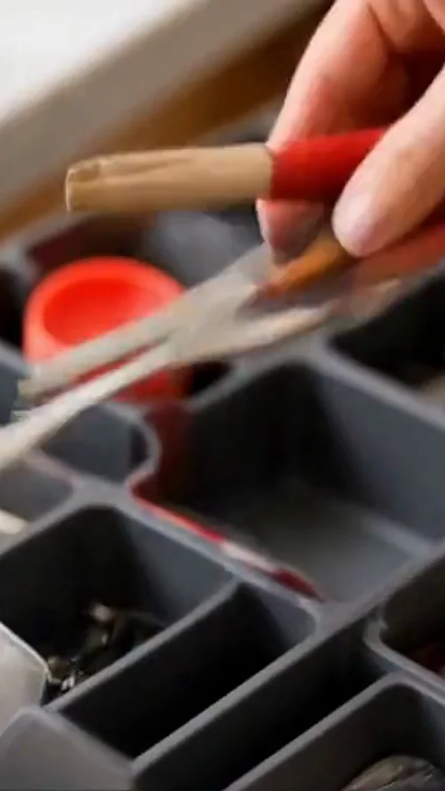 Hands organize gray drawer dividers and utensils in a vertical home organization video frame.