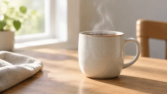 Ceramic mug with gentle steam rising in soft morning light.