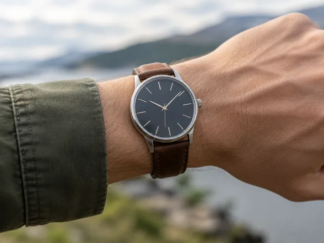 Leather-strap watch on a wrist outdoors.