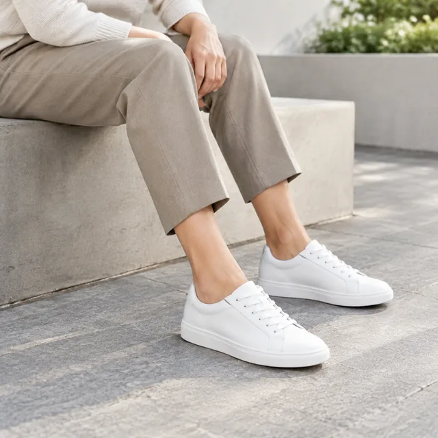 White casual shoes worn with cropped trousers.