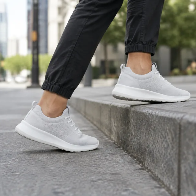 Sneakers stepping up onto a city curb.
