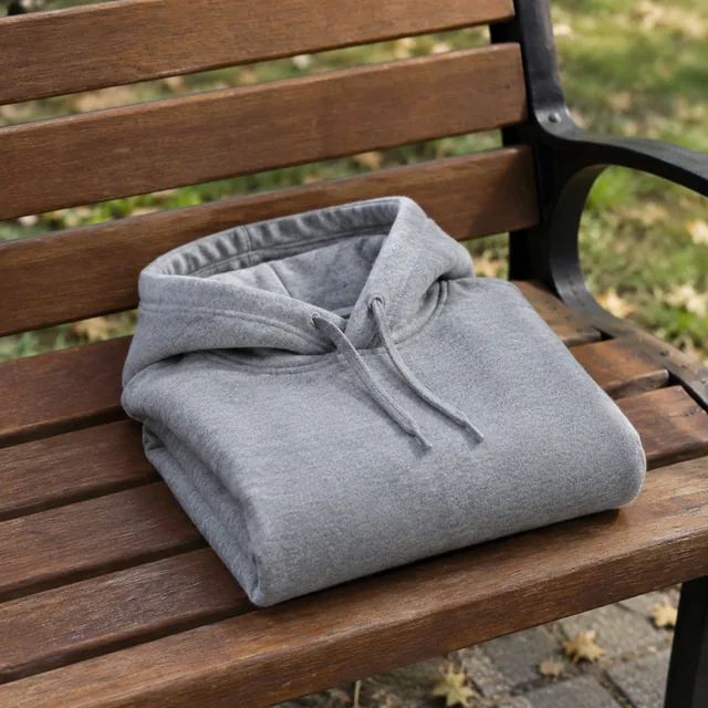 Gray hoodie folded on a park bench.