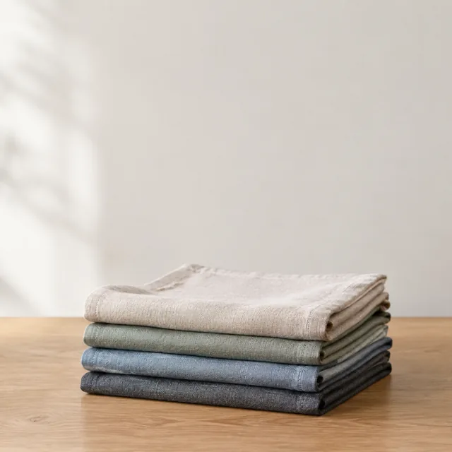 Folded linen napkins on a table with quiet empty space above them.