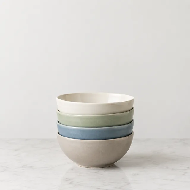 Stacked ceramic bowls on a counter with open space above them.