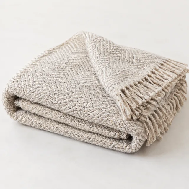 Throw blanket folded to show its weave texture, light background.