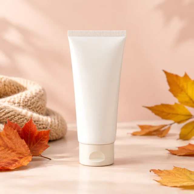 Hand cream tube front view on a pastel backdrop.