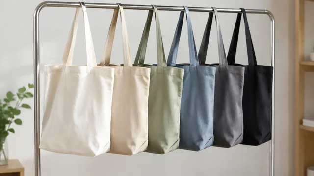 Restocked canvas tote bags hanging on a studio rail.