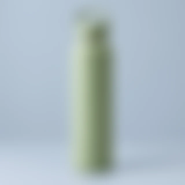 The same square green-bottle scene softened by blur so its surface details are hard to inspect.