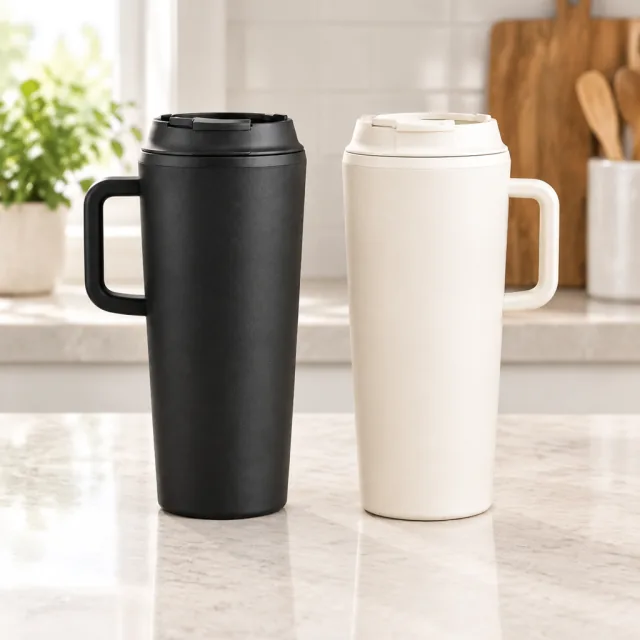 Matte black and warm cream insulated tumblers standing side by side on a counter.