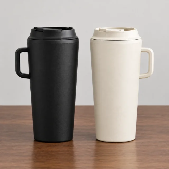 The same matte black and warm cream insulated tumblers standing on a walnut desk.