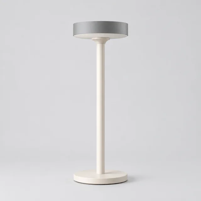 White sculptural desk lamp with a saucer-shaped shade photographed alone.