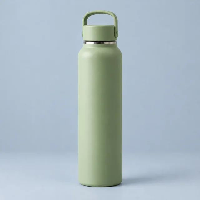 Sage green insulated bottle with its hinged loop handle on a soft blue-gray background.