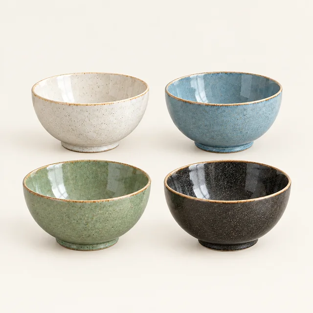 Four coordinated cream, blue, green, and charcoal ceramic bowls in a square product scene.