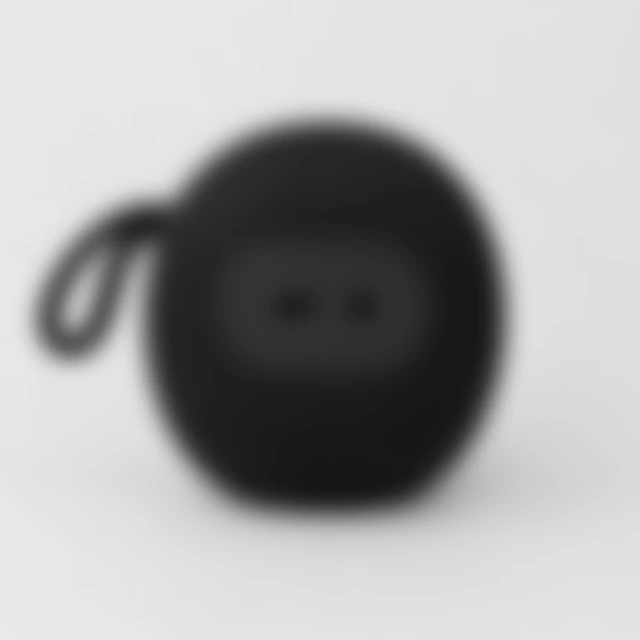 Portable speaker ports and woven grille softened by blur.