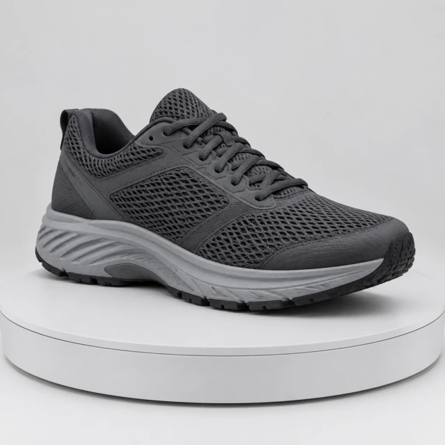 Charcoal performance running shoe turning on a plain studio turntable, visible mesh and sole, no brand marks.