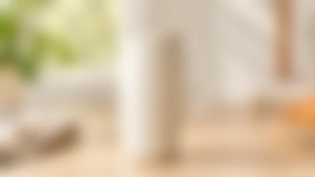 The same matte ceramic travel mug softened by heavy blur so its rim and handle lose definition.