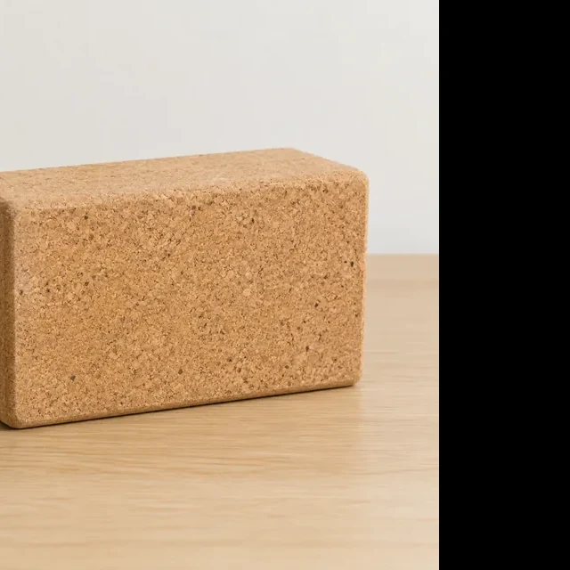The same cork yoga block cropped tightly through its left edge.
