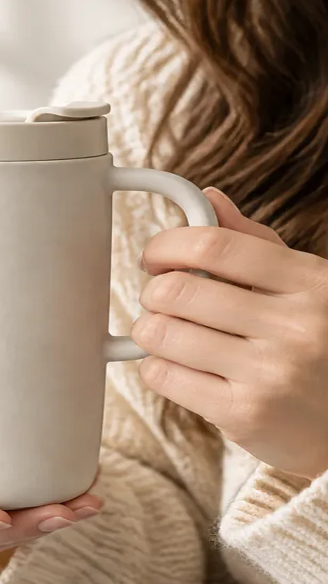 Travel mug clipped along the left edge in a hand-held scale view.