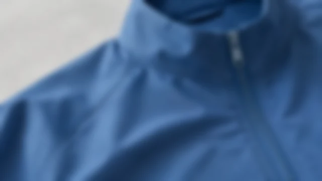 Blue jacket fabric with its weave softened out of focus.