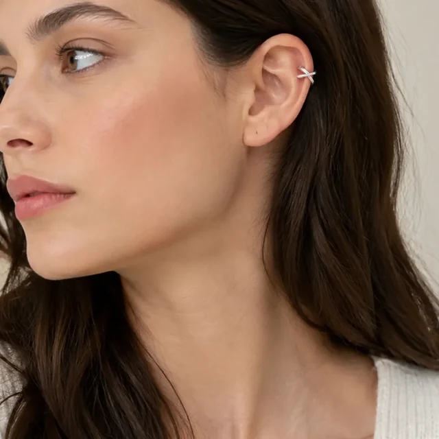 The same silver ear cuff enlarged until the model and ear are cropped at the frame edges.