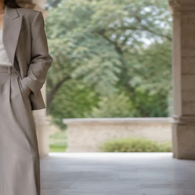 Wide-leg suit cropped tightly with part of the outfit cut off at the edge.