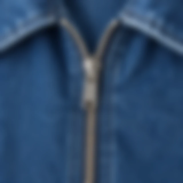 Close detail of the denim jacket zipper and seams blurred from the paired sharp image.