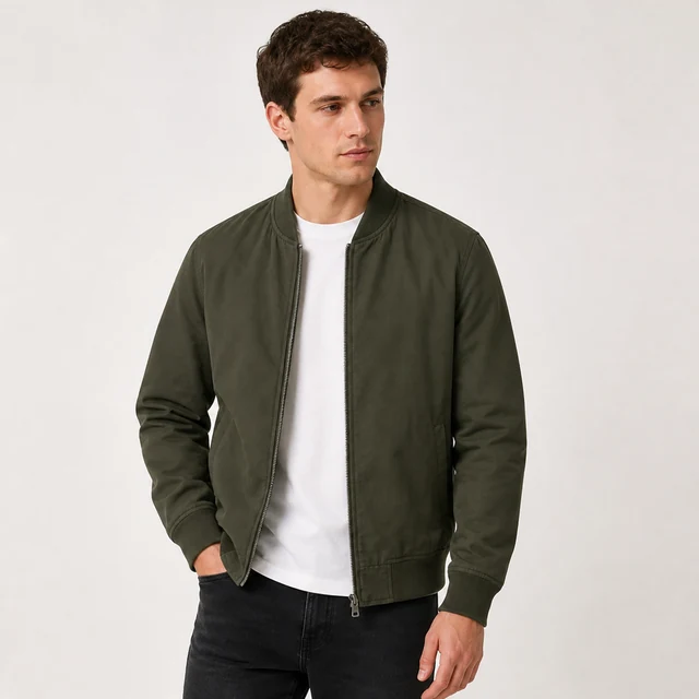 Adult model wearing the olive bomber jacket over a plain white shirt in a studio.