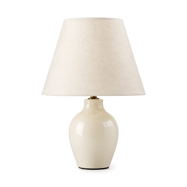 Ceramic table lamp with an ivory linen shade on pure white.