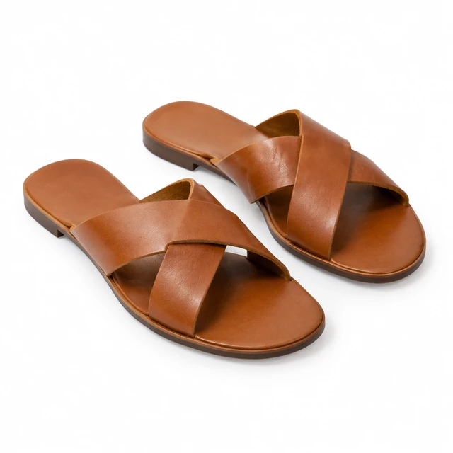 Pair of cognac leather sandals with both straps fully visible on white.