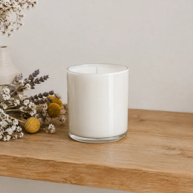 Plain candle jar on a styled shelf with open space beside it.