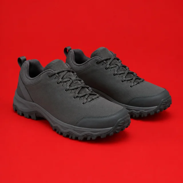 Pair of plain charcoal hiking shoes with smooth side panels on a bold red backdrop.