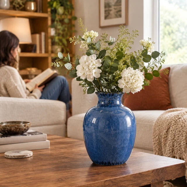 Blue ceramic vase in a warm living room setting.
