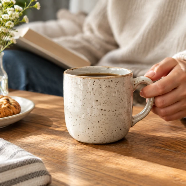 Speckled ceramic cup in a clean square frame.