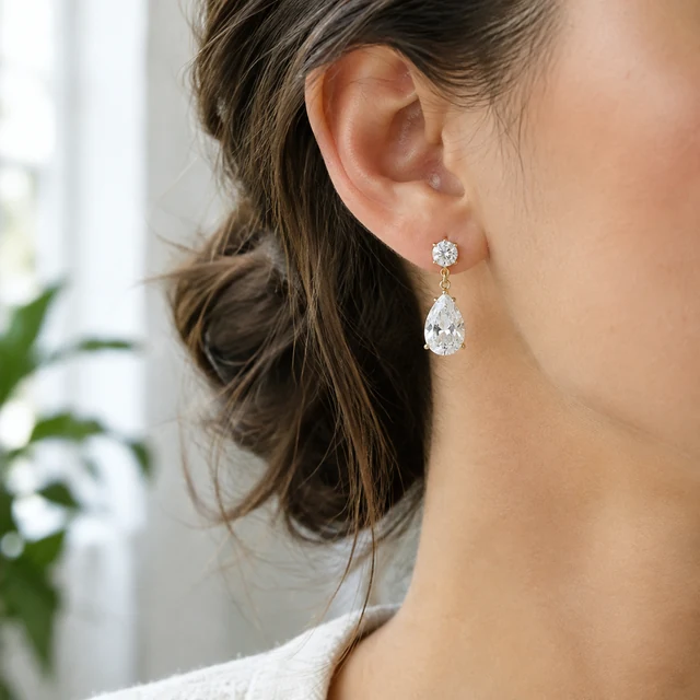 Drop earrings worn in soft window light