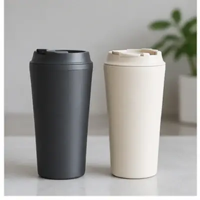Coffee pours between two insulated mugs